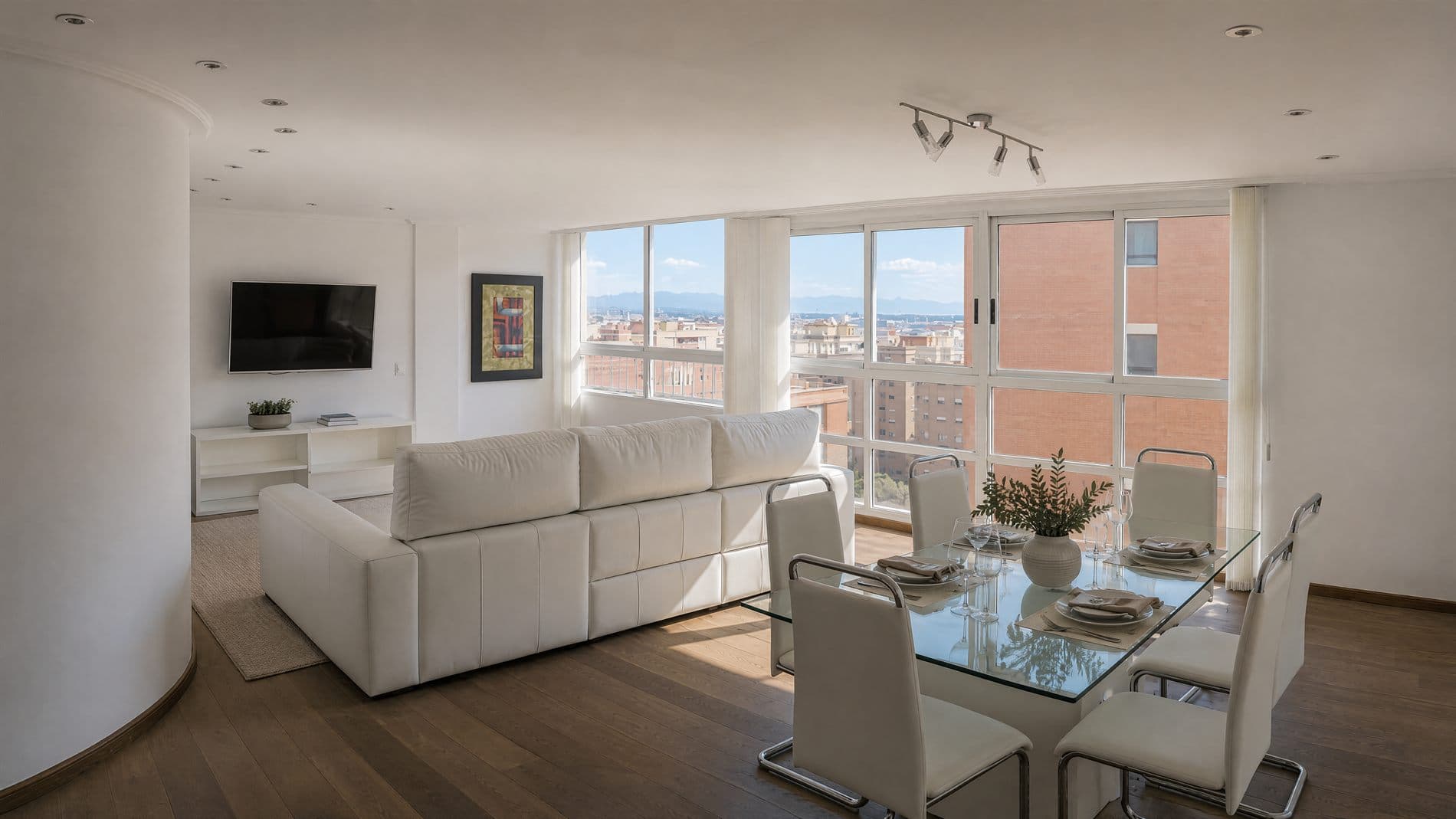 Salón-comedor del ático dúplex de Benimaclet con grandes ventanales y vistas